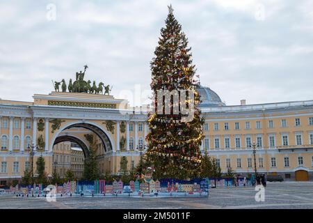 SANKT PETERSBURG, RUSSLAND - 20. DEZEMBER 2022: Weihnachtsbaum und Triumphbogen des Generalstabsgebäudes an einem bewölkten Dezembertag. Palastplatz Stockfoto