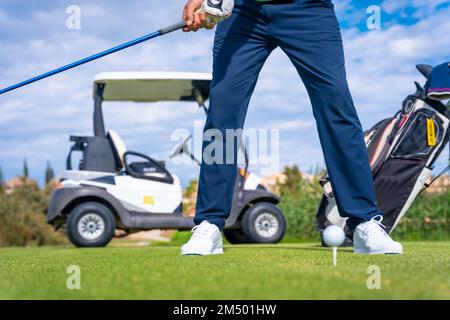 Ein malerischer Blick auf einen Mann, der sich bereit macht, den Golfball mit einem Golfschläger zu schlagen Stockfoto