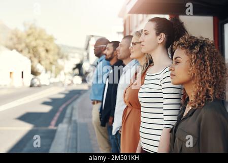 Sie haben hier draußen viel zu erreichen. Eine Gruppe von Menschen, die in der Stadt in einer Schlange stehen. Stockfoto