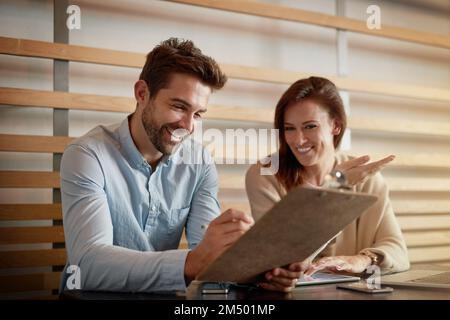 Das Geschäft sieht gut aus. Zwei Geschäftsleute treffen sich in einem Café. Stockfoto