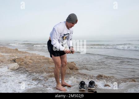 Chicago, USA. 23. Dezember 2022 Wetter in Chicago: Henry Clark, 26, ein Helikopterpilot aus Evanston, zieht sich nach einem Bad im Lake Michigan am zweiten Tag des Wintersturms in Chicago an, wo die Temperaturen derzeit bei -20C sind. Was als „Bombencyclon“ bezeichnet wird, der vielen ein weißes Weihnachtsfest garantiert, trifft große Teile des Landes mit eiskalten Temperaturen. Kredit: Stephen Chung / Alamy Live News Stockfoto