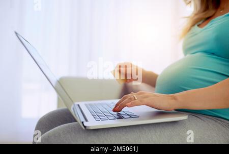 Bequemes Einkaufen. Nahaufnahme einer schwangeren Frau, die zu Hause online einkauft. Stockfoto