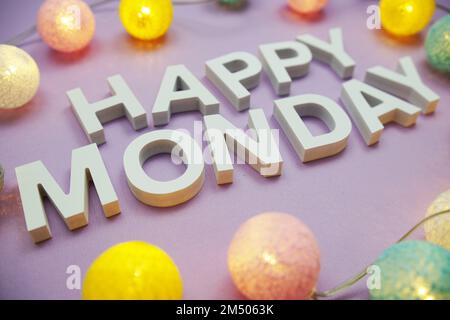 Happy Monday Alphabet letters with LED Cotton balls on lila background. (Alles gute zum Montag, Alphabet mit LED-Baumwoll Stockfoto