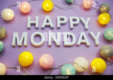 Happy Monday Alphabet letters with LED Cotton balls on lila background. (Alles gute zum Montag, Alphabet mit LED-Baumwoll Stockfoto