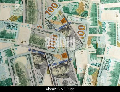 US-Dollar-Scheine mit pakistanischen 500 Rupien-Banknoten Stockfoto