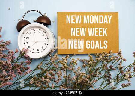 Neuer Montag Neue Woche Neue Ziele Wort mit Wecker auf blauem Hintergrund Stockfoto