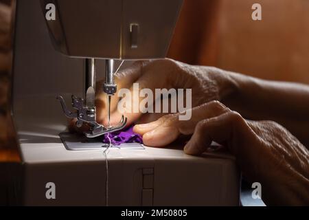 Nähmaschine und die Hand der alten Großmutter Stockfoto