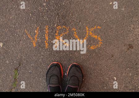 Das Wort Virus wird in englischer Kreide auf dem Asphalt geschrieben Stockfoto