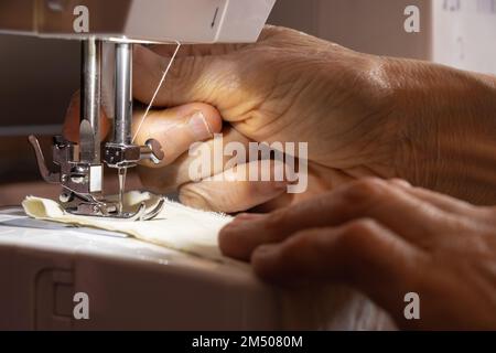 Nähmaschine und die Hand der alten Großmutter Stockfoto