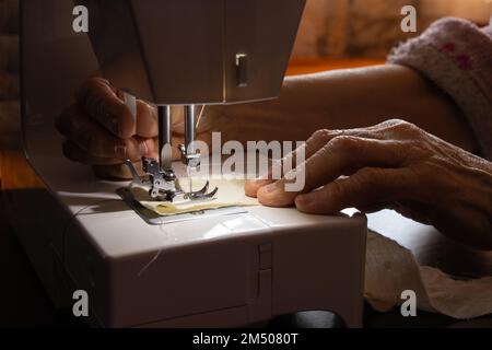 Nähmaschine und die Hand der alten Großmutter Stockfoto