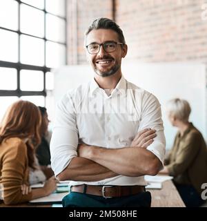 Sie sind der Autor Ihrer eigenen Erfolgsgeschichte. Porträt eines selbstbewussten Geschäftsmannes, der während einer Besprechung im Sitzungssaal steht. Stockfoto