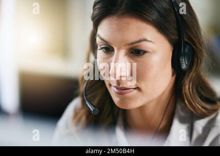 Sie hört jeder Kundenanfrage aufmerksam zu. Eine Agentin, die in einem Callcenter arbeitet. Stockfoto