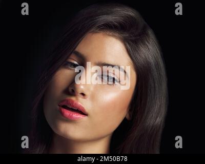 Nahaufnahme und noch makelloser. Studio-Nahaufnahme einer schönen Frau, die vor schwarzem Hintergrund posiert. Stockfoto
