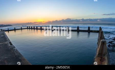 Strand Ozean Gezeitenpool mit ruhigem Meerwasser bei Sonnenaufgang am Horizont eine malerische Küstenlandschaft. Stockfoto