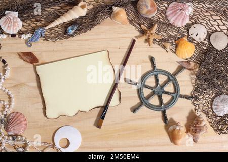 Leeres Papier mit verbrannten Kanten auf Holzhintergrund mit Meeresmuscheln und Fischernetz. Nautisches und Küstenthema Stockfoto