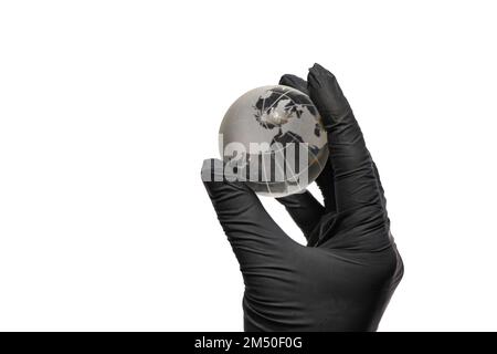 Die Hand in schwarzen Handschuhen trägt eine Glaskugel auf einer weißen Stockfoto