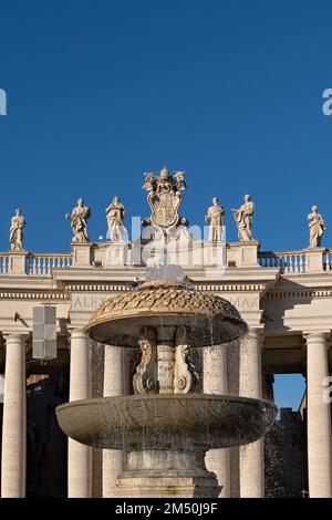 Petersplatz Piazza San Pietro, Bernini-Kolonnade, Wappen. Maderno-Brunnen, blauer Himmel. Speicherplatz kopieren. Vatikanstadt, Rom, Italien, Europa Stockfoto