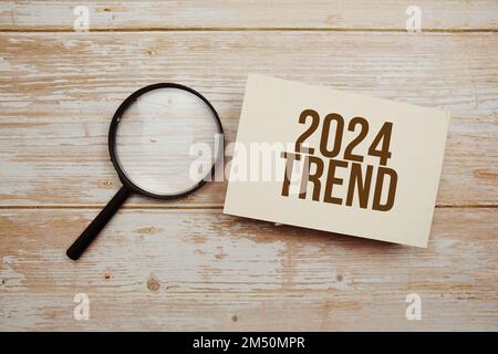 Trend 2024 Textnachricht und Lupe mit Space Copy auf Holzhintergrund Stockfoto