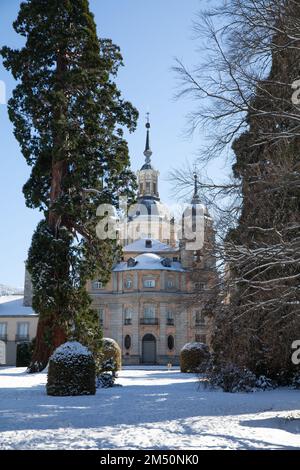 Segovia, Spanien - 4. Januar 2022: Royal Collegiate Church of the Palace of La Granja de San Ildefonso mit Schnee an einem sonnigen Wintertag Stockfoto