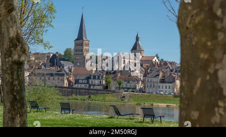 Ein horizontaler Blick mit Bäumen auf dem Kirchturm und der Kirche der Priory von La-Charité-sur-Loire, von einer Insel aus gesehen, die über einen Zweig der verläuft Stockfoto