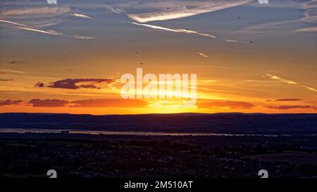 Blick auf den Sonnenuntergang über dem Fluss Severn von Cam Long Down, Dursley, Gloucestershire, Großbritannien Stockfoto