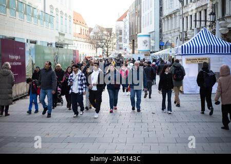 München, Deutschland. 24. Dezember 2022. Christkindlmarkt am 24. Dezember 2022 in München. Besucher trinken Glühwein oder Punsch und essen Bratwurst, Tarte Flambee, Pommes Frites oder Süßigkeiten. (Foto: Alexander Pohl/Sipa USA) Guthaben: SIPA USA/Alamy Live News Stockfoto