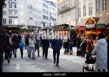 München, Deutschland. 24. Dezember 2022. Christkindlmarkt am 24. Dezember 2022 in München. Besucher trinken Glühwein oder Punsch und essen Bratwurst, Tarte Flambee, Pommes Frites oder Süßigkeiten. (Foto: Alexander Pohl/Sipa USA) Guthaben: SIPA USA/Alamy Live News Stockfoto