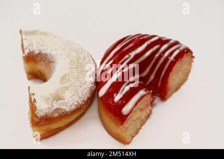 Puderzucker und Ringdonut mit Erdbeergeschmack, glasierter, hefegezogener, amerikanischer Ringdonut mit Belag, Art Foo Stockfoto