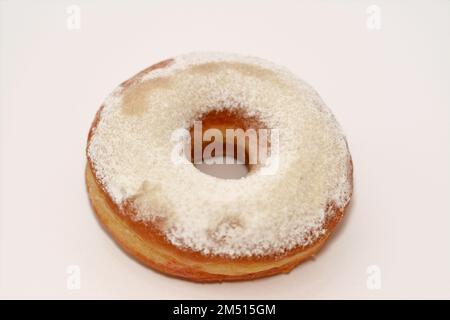 Puderzucker-Ring-Donut, Glasierter, hefegezogener, amerikanischer Ring-Donut mit Garnierung aus fein gemahlenem Zucker der Konditoren, Art der Nahrung Stockfoto