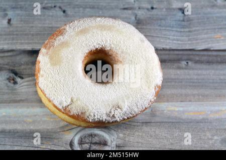Puderzucker-Ring-Donut, Glasierter, hefegezogener, amerikanischer Ring-Donut mit Garnierung aus fein gemahlenem Zucker der Konditoren, Art der Nahrung Stockfoto