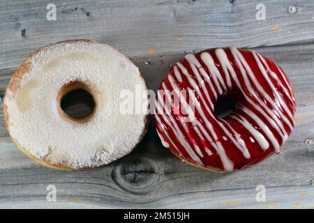 Puderzucker und Ringdonut mit Erdbeergeschmack, glasierter, hefegezogener, amerikanischer Ringdonut mit Belag, Art Foo Stockfoto