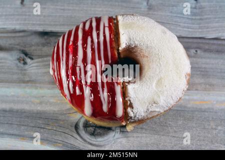 Puderzucker und Ringdonut mit Erdbeergeschmack, glasierter, hefegezogener, amerikanischer Ringdonut mit Belag, Art Foo Stockfoto