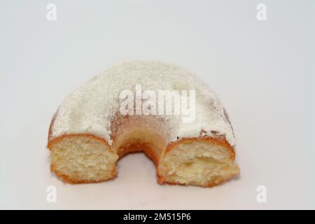 Puderzucker-Ring-Donut, Glasierter, hefegezogener, amerikanischer Ring-Donut mit Garnierung aus fein gemahlenem Zucker der Konditoren, Art der Nahrung Stockfoto