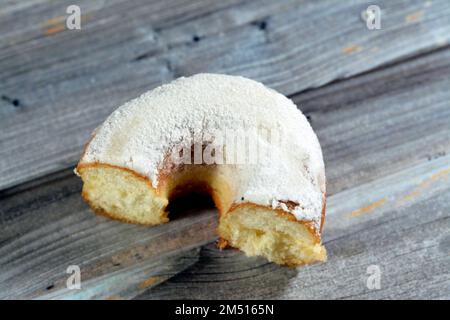 Puderzucker-Ring-Donut, Glasierter, hefegezogener, amerikanischer Ring-Donut mit Garnierung aus fein gemahlenem Zucker der Konditoren, Art der Nahrung Stockfoto