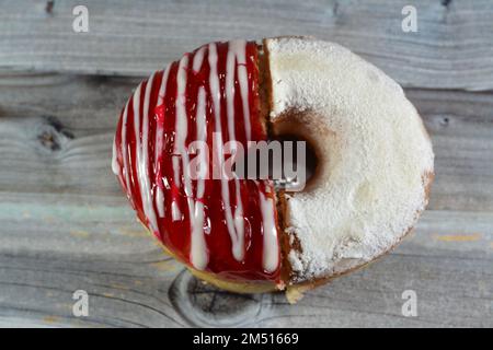 Puderzucker und Ringdonut mit Erdbeergeschmack, glasierter, hefegezogener, amerikanischer Ringdonut mit Belag, Art Foo Stockfoto