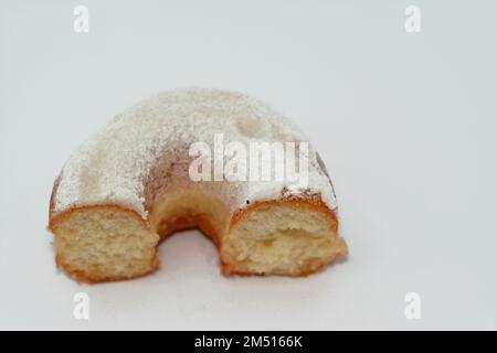 Puderzucker-Ring-Donut, Glasierter, hefegezogener, amerikanischer Ring-Donut mit Garnierung aus fein gemahlenem Zucker der Konditoren, Art der Nahrung Stockfoto