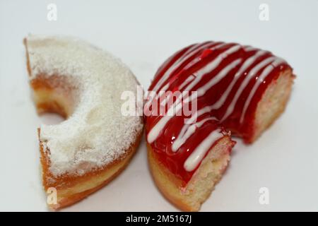Puderzucker und Ringdonut mit Erdbeergeschmack, glasierter, hefegezogener, amerikanischer Ringdonut mit Belag, Art Foo Stockfoto