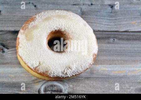 Puderzucker-Ring-Donut, Glasierter, hefegezogener, amerikanischer Ring-Donut mit Garnierung aus fein gemahlenem Zucker der Konditoren, Art der Nahrung Stockfoto