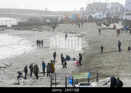 Lyme Regis, Dorset, Großbritannien. 24. Dezember 2022 Wetter in Großbritannien. Der Strand ist voll mit Familien im Lyme Regis in Dorset, da sie einen warmen, bedeckten Tag am Heiligabend genießen. Bildnachweis: Graham Hunt/Alamy Live News Stockfoto