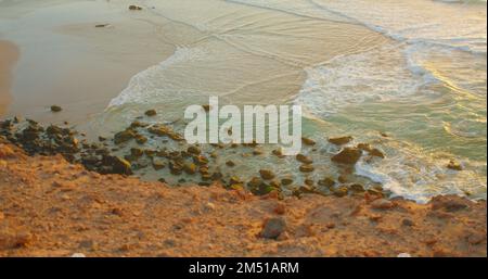 Meer und Felsen am wunderschönen natürlichen Felsenstrand bei Sonnenuntergang im Sommer. Wellen am Meer des wilden Paradieses. Unberührte, klare Meeresküste. Transparent Stockfoto