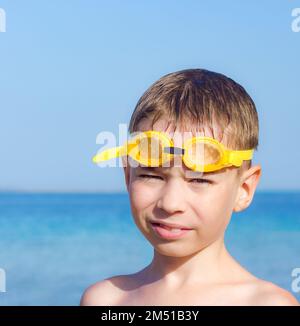 Ein Junge mit einer hellgelben Badebrille Stockfoto