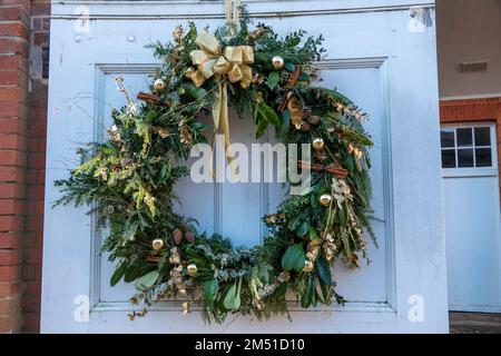 weihnachtskranz an der Tür mit goldenen Kugeln und Zimtstangen Stockfoto