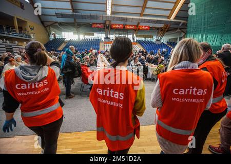 Sopot, Polen. 24. Dezember 2022. Am 24. Dezember 2022 nahmen mehr als 300 Personen an der Weihnachtsfeier in Sopot (Polen) Teil. Die christliche Wohltätigkeitsorganisation Caritas Polens organisierte ein traditionelles polnisches Weihnachtsessen. Die Leute teilten sich eine besondere Waffel, wenn sie Weihnachtsgrüße austauschten. Obdachlose und Arme wurden mit traditionellen polnischen Bigos, Pierogi, Fisch, Brot und Kuchen begrüßt. Kredit: Vadim Pacajev/Alamy Live News Stockfoto