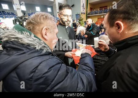 Sopot, Polen. 24. Dezember 2022. Am 24. Dezember 2022 nahmen mehr als 300 Personen an der Weihnachtsfeier in Sopot (Polen) Teil. Die christliche Wohltätigkeitsorganisation Caritas Polens organisierte ein traditionelles polnisches Weihnachtsessen. Die Leute teilten sich eine besondere Waffel, wenn sie Weihnachtsgrüße austauschten. Obdachlose und Arme wurden mit traditionellen polnischen Bigos, Pierogi, Fisch, Brot und Kuchen begrüßt. Kredit: Vadim Pacajev/Alamy Live News Stockfoto