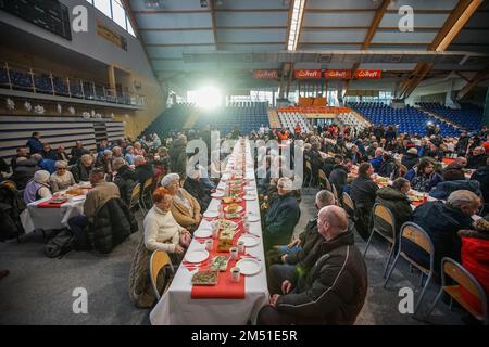 Sopot, Polen. 24. Dezember 2022. Am 24. Dezember 2022 nahmen mehr als 300 Personen an der Weihnachtsfeier in Sopot (Polen) Teil. Die christliche Wohltätigkeitsorganisation Caritas Polens organisierte ein traditionelles polnisches Weihnachtsessen. Die Leute teilten sich eine besondere Waffel, wenn sie Weihnachtsgrüße austauschten. Obdachlose und Arme wurden mit traditionellen polnischen Bigos, Pierogi, Fisch, Brot und Kuchen begrüßt. (Foto: Vadim Pacajev/Sipa USA) Guthaben: SIPA USA/Alamy Live News Stockfoto