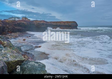 Massive Wellen und Sprühnebel an der Küste nahe Glace Bay Cape Breton nach einem Atlantiksturm Ende Dezember. Stockfoto