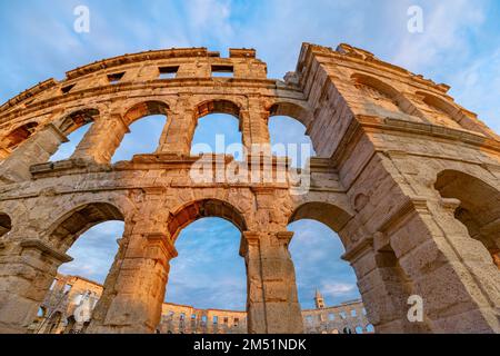 Das Pula Amphitheater bei Sonnenuntergang, auch bekannt als Kolosseum von Pula, ist ein gut erhaltenes römisches Amphitheater in Pula, Istrien, Kroatien. Eine antike Arena wurde gebaut Stockfoto