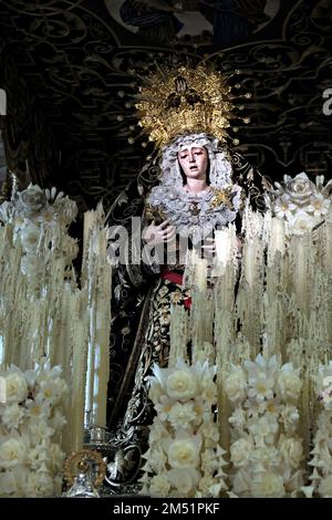 Statue des Nuestra Señora de la Esperanza, aus Triana, auf dem paso mit Kerzen in Sevilla Stockfoto