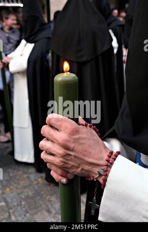 Begleitet die Pasos im Reiseplan der „Stationen der Buße“. Nahaufnahme der Hände mit der Kerze Stockfoto