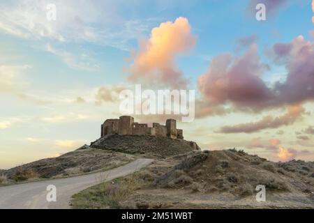 Blick auf die Ruinen der verlassenen mittelalterlichen Burg Montearagon bei Sonnenuntergang, auf einem Berg in der Nähe von Huesca, Provinz Aragon, Spanien. Stockfoto